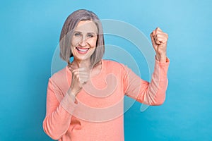 Photo of funny retired woman gray hair wear peachy trendy shirt raised fists up celebrate victory shopping offer