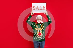 Photo of funny santa man hold paper placard with sale announcement inviting buyers to shop wear specs x-mas ugly