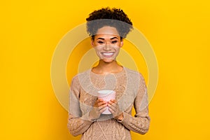 Photo of funny young brunette lady hold cup wear beige pullover isolated on yellow color background