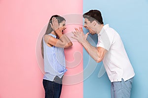 Photo of furious man and woman in casual clothes screaming at ea