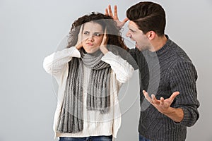 Photo of furious man and woman screaming at each other standing face to face, isolated over gray background