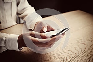 Photo of generic design smart phone holding in female hands for texting message. Horizontal