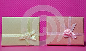 Photo of a gift box with a bow under points of view on a pink background front view