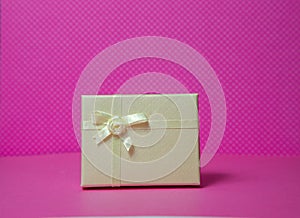 Photo of a gift box with a bow under points of view on a pink background front view