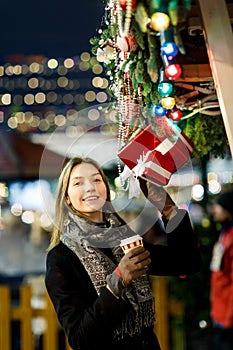 Photo of girl with glass in hands near boxes with gifts