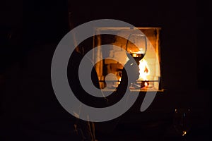 Photo of girl silhoette with glass near fireplace for graphic and web design, for website or mobile app.