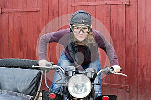 Photo of girl on a vintage motorbike in pilot cap