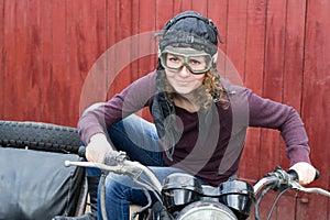 Photo of girl on a vintage motorbike in pilot cap