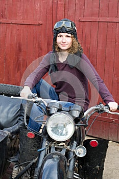 Photo of girl on a vintage motorbike in pilot cap