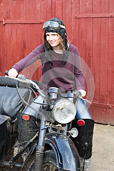 Photo of girl on a vintage motorbike in pilot cap