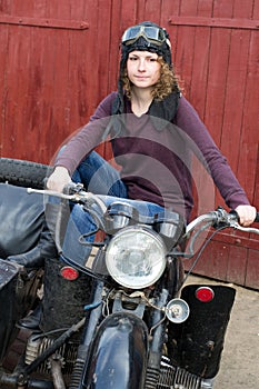 Photo of girl on a vintage motorbike in pilot cap