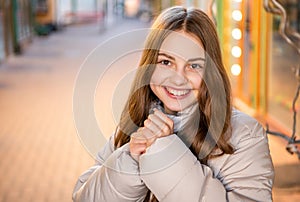 photo of glad teenage girl portrait outside. teenage girl portrait in the street.