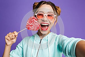 Photo of glamour woman 20s in sunglasses holding big candy and t