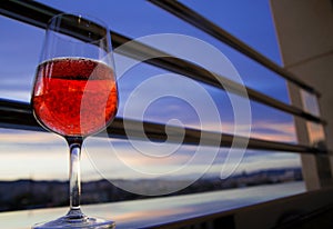 A glass of red wine on the balcony in the evening