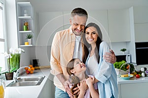 Photo of good mood adorable dad mom small daughter embracing spending weekend together indoors home kitchen