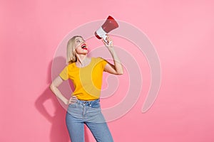 Photo of good mood funky woman wear yellow t-shirt yelling loud speaker empty space isolated pink color background