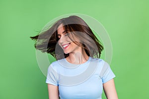 Photo of gorgeous cheerful girl closed eyes toothy smile flying hair isolated on green color background