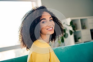 Photo of gorgeous cheerful lovely nice woman with perming coiffure wear yellow long sleeve toothy smiling to you at home