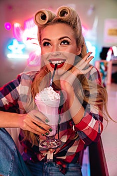 Photo of gorgeous cheerful woman drinking milkshake and smiling