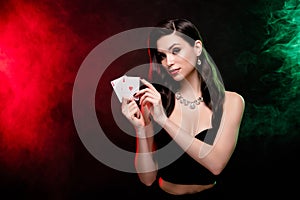 Photo of gorgeous chic lady poker play hold two ace cards blackjack winning over dark background with light mist neon