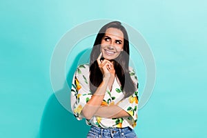 Photo of gorgeous minded woman dressed flower print blouse finger on cheekbone look empty space isolated on turquoise