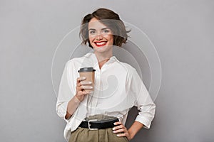 Photo of gorgeous woman 20s smiling and holding takeaway coffee