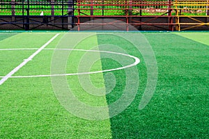 Photo of a green synthetic grass sports field with white line sh