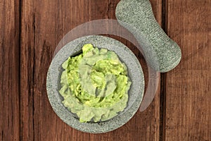 A photo of guacamole sauce in a molcajete, traditional Mexican bowl