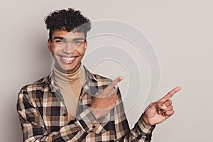 Photo of guy direct forefingers empty space advising wear checkered shirt rollneck isolated grey color background