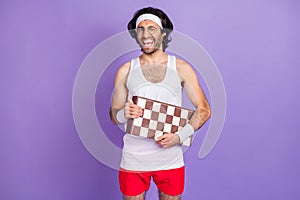 Photo of guy hold chess board blink eye open mouth wear headband sportswear eyewear isolated violet background