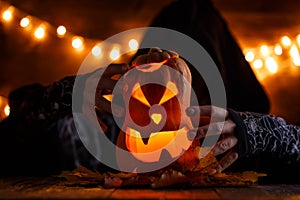 Photo of halloween pumpkin cut in shape of face with witch