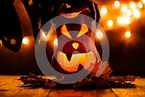 Photo of halloween pumpkin cut in shape of face with witch`s hand