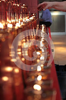 photo of a hand taking a candle to pray at the monastery