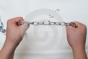 Photo of hands holding a broken chain