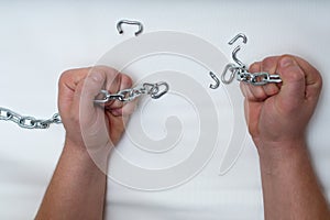 Photo of hands holding a broken chain