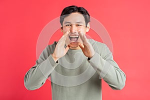 A photo of a handsome asian man covering his mouth with his hands screamed in joy