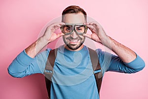 Photo of handsome cute young guy wear blue pullover arms glasses backpack ready to skydive isolated pink color