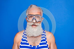 Photo of handsome happy positive smiling old man in goggles wear swimming suit isolated on blue color background