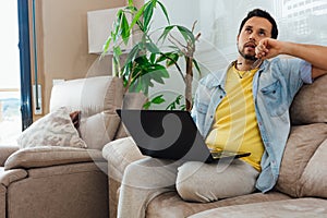 Photo of a handsome Hispanic man using a laptop - communication, leisure, and people concept