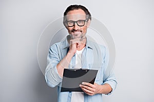 Photo of handsome hr man happy positive smile think hold clipboard interview vacancy hire isolated over grey color