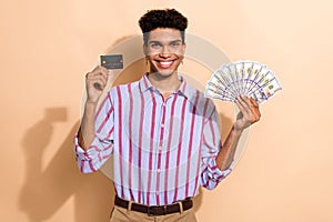 Photo of handsome male device hold money fan credit card dressed stylish striped formalwear outfit isolated on beige