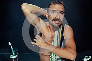 Photo of handsome man shaving his armpit