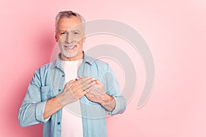 Photo of handsome retired man arms on heart promise honest grateful isolated over pink color background