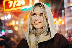 Photo of happy blonde on blurred background of city lights