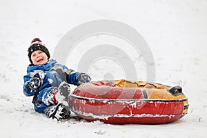 Photo of happy boy with tubing in winter park