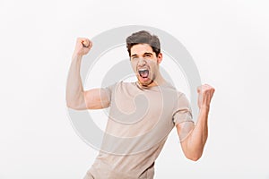 Photo of happy brunette guy rejoicing and clenching fists like w