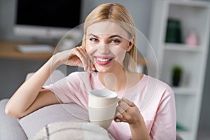 Photo of happy charming nice pretty young woman sit sofa drink coffee mug indoors inside house home