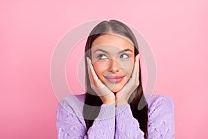 Photo of happy dreamy young woman hold hands face look empty space isolated on pink color background