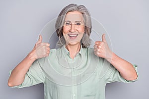 Photo of happy excited cheerful good mood mature woman showing thumb-up approval isolated on grey color background