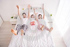 Photo of happy family barefoot mommy daddy daughter lying sheets good mood having fun spend together quarantine weekend
